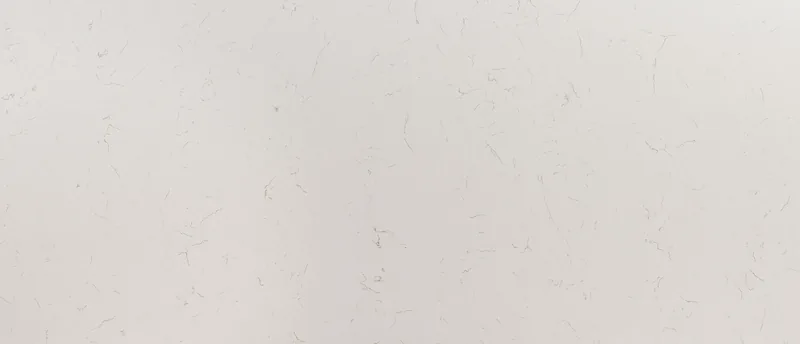 MSI Q Quartz Carrara Trigato quartz slab: warm white background with short, scattered brownish gray veins
