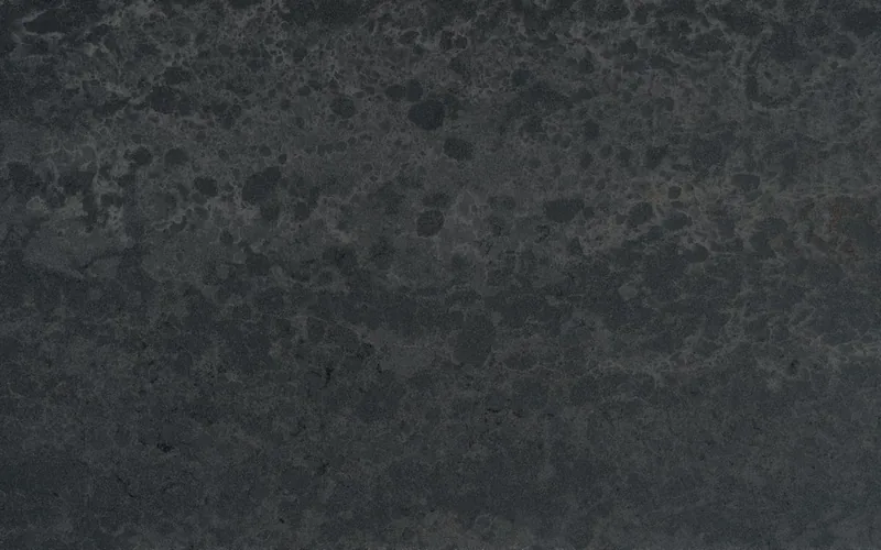 Silestone Raw D countertop swatch: charcoal background with diffused bronze streaks