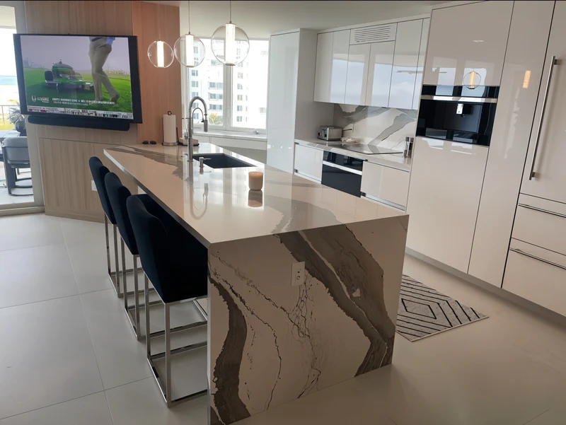 Condo kitchen with Brittanicca quartz and navy stools
