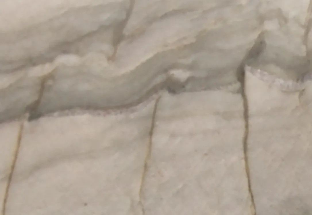 Polished white quartzite slab with layered gray banding