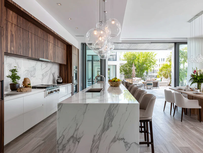 Modern kitchen with marble island and glass pendant lights